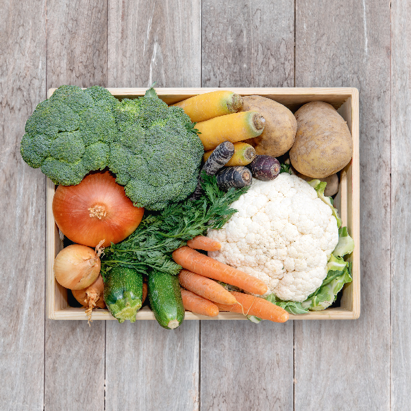 Obsthaus Kochgemüse-Kiste auf Holzboden mit allerlei Kochgemüse