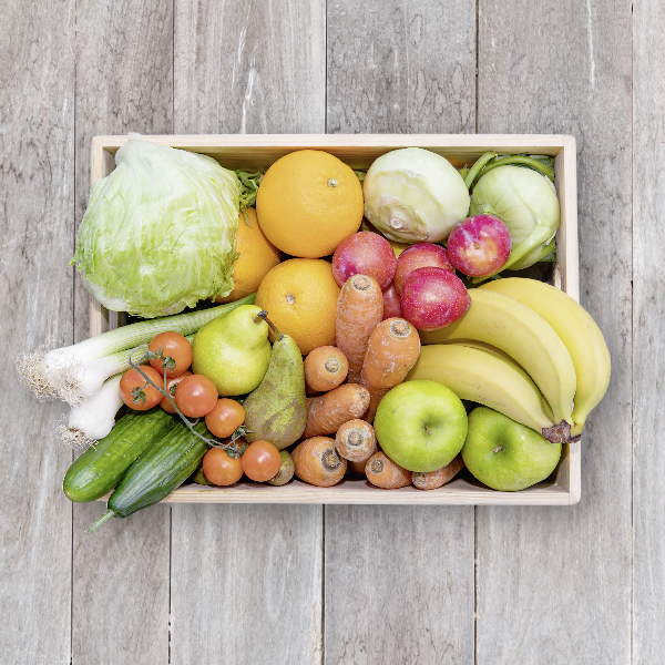 Obsthaus Mix-Kiste auf Holzboden mit allerlei Gemüse und Früchten